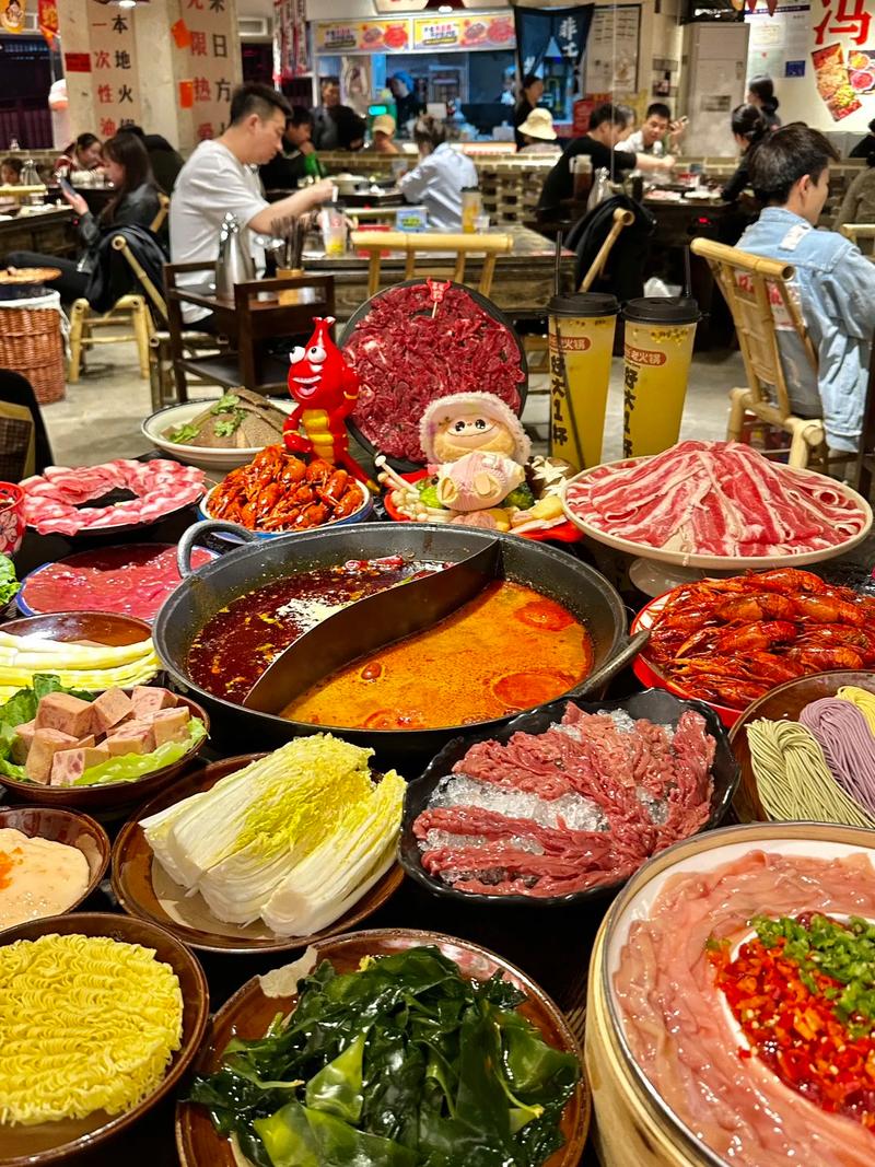Sichuan hot pot spread with sliced meats, vegetables, noodles and a split mala broth pot